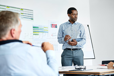 Buy stock photo Shot of a man giving a presentation to colleagues in an office boardroom