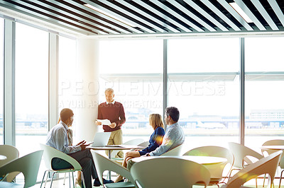 Buy stock photo Shot of a group of colleagues talking together in a modern office