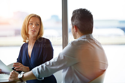 Buy stock photo Shot of two businesspeople sitting in the boardroom during a meeting