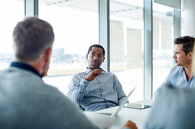 Buy stock photo Shot of three professional businessmen meeting in their office
