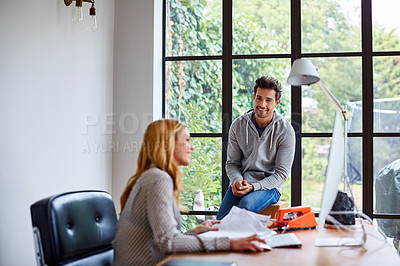 Buy stock photo Shot of a young couple working together in their home office