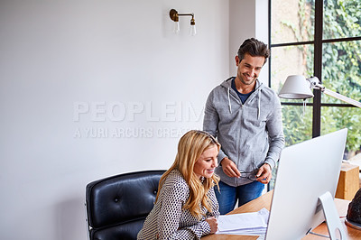 Buy stock photo Shot of a young couple working together in their home office
