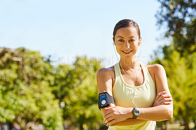 Buy stock photo Cropped portrait of an attractive and athletic young sportswoman listening to music while out for a jog in the park
