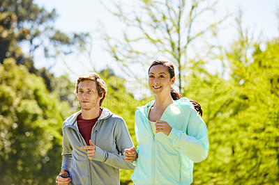 Buy stock photo Cropped shot of an affectionate and athletic young couple out for a jog in the park