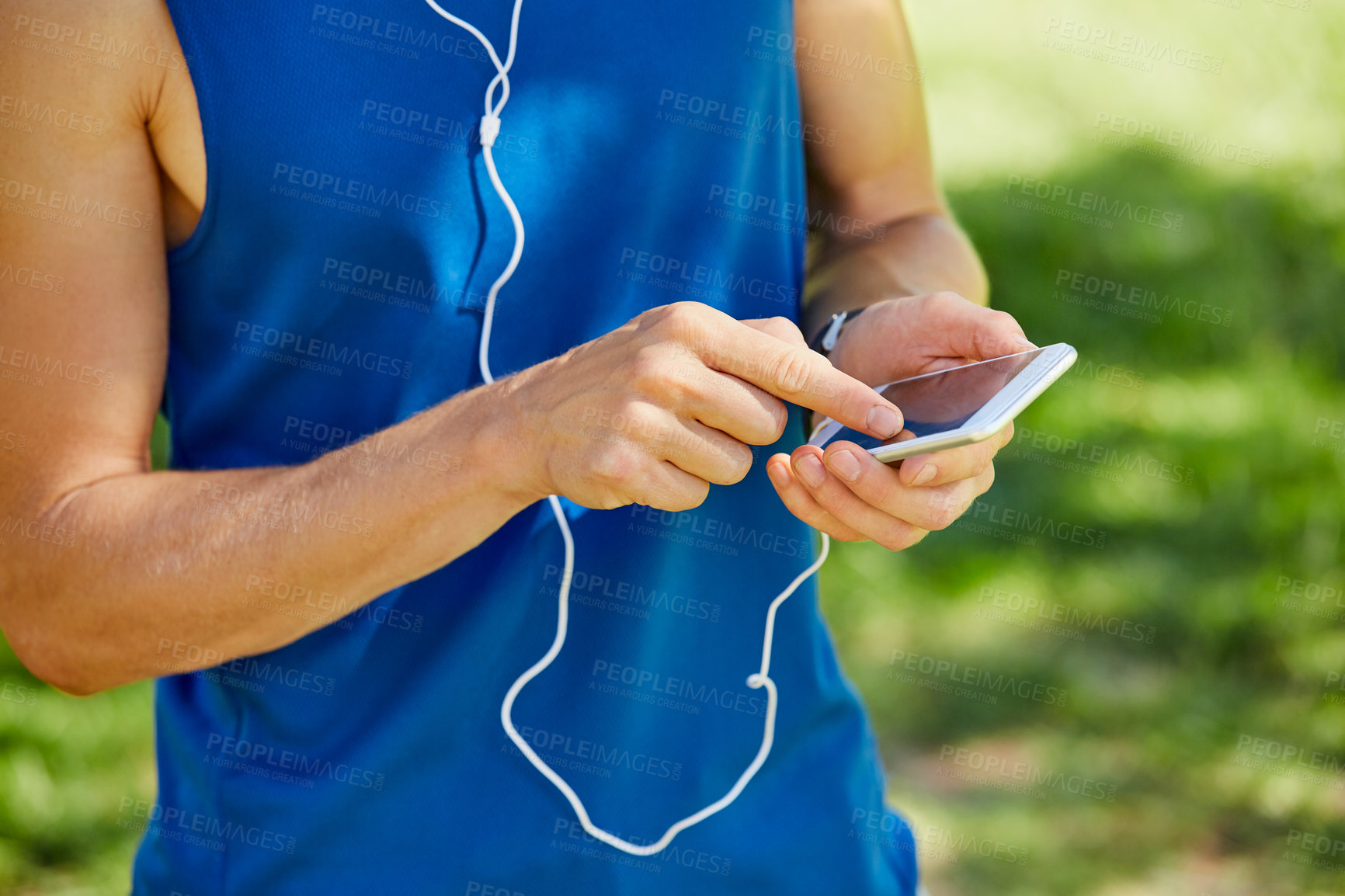 Buy stock photo Cropped shot of an unrecognizable and athletic young sportsman sending a text while out for a jog in the park