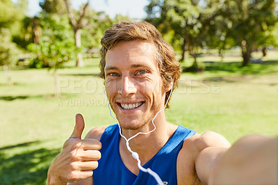 Buy stock photo Cropped portrait of a handsome and athletic young sportsman listening to music while out for a jog in the park