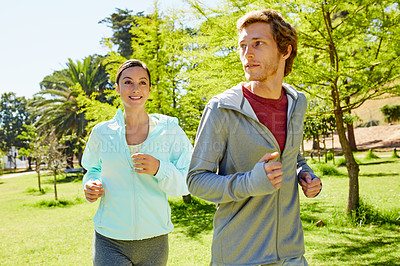 Buy stock photo Cropped shot of an affectionate and athletic young couple out for a jog in the park