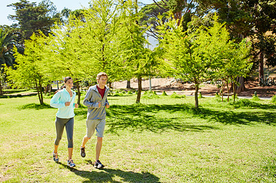 Buy stock photo Full length shot of an affectionate and athletic young couple out for a jog in the park