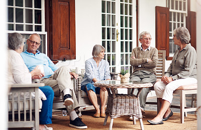 Buy stock photo Full length shot of a group of senior citizens sitting together and enjoying a day out on the veranda