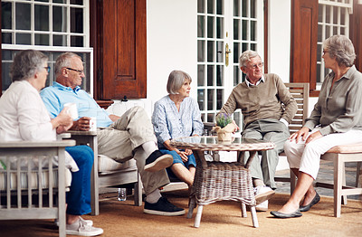 Buy stock photo Full length shot of a group of senior citizens sitting together and enjoying a day out on the veranda