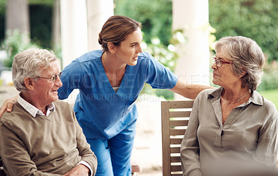 Buy stock photo Cropped shot of an attractive young nurse bonding with her senior patients during a tea party