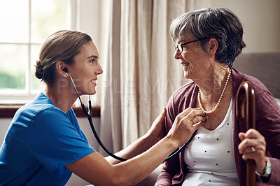 Buy stock photo Shot of a nurse examining a senior woman with a stethoscope at home