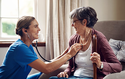 Buy stock photo Shot of a nurse examining a senior woman with a stethoscope at home