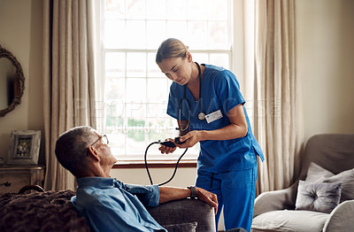 Buy stock photo Shot of a senior man getting his blood pressure measured during a checkup with a nurse at home
