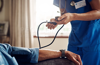 Buy stock photo Shot of a senior man getting his blood pressure measured during a checkup with a nurse at home