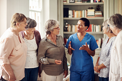 Buy stock photo Cropped shot of an attractive young nurse standing with her senior patients in the living room of a nursing home