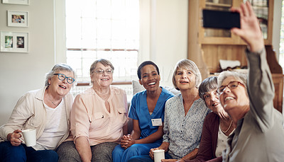 Buy stock photo Cropped portrait of a happy senior woman using her cellphone to take a selfie with her friends and nurse