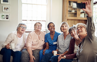 Buy stock photo Cropped portrait of a happy senior woman using her cellphone to take a selfie with her friends and nurse