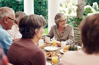 Buy stock photo Cropped shot of a group of senior citizens sitting together and enjoying a tea party outdoors