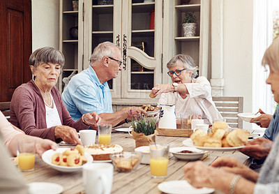 Buy stock photo Cropped shot of a senior man offering his female friend a biscuit during a tea party outdoors