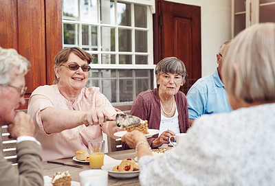 Buy stock photo Cropped shot of a happy senior woman serving carrot cake to her friend during a tea party outdoors