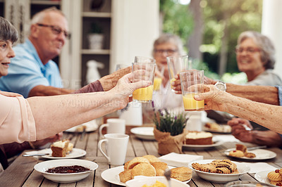 Buy stock photo Cropped shot of a group of seniors sitting together and raising their fruit juice glasses for a toast