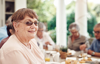 Buy stock photo Cropped portrait of a happy senior woman sitting and enjoying a tea party with her friends outdoors