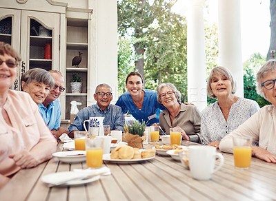 Buy stock photo Cropped portrait of an attractive young nurse bonding with her senior patients during a tea party