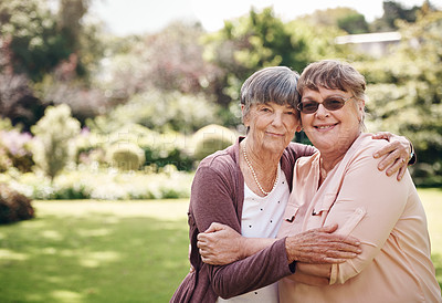 Buy stock photo Cropped portrait of two senior women holding each other during a day out in the garden