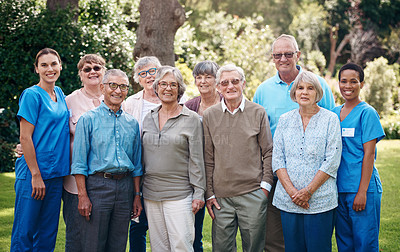 Buy stock photo Cropped portrait of two attractive young nurses standing with their happy senior patients during a day out in the garden
