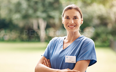 Buy stock photo Portrait of a confident young nurse standing outside in the garden of a retirement home