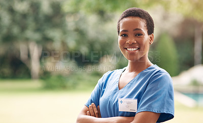 Buy stock photo Portrait of a confident young nurse standing outside in the garden of a retirement home