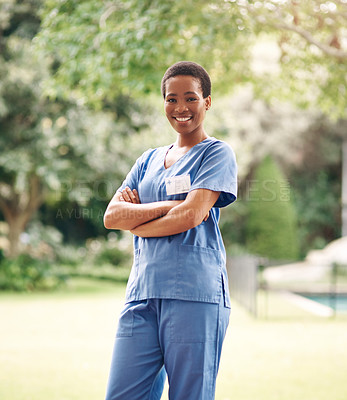 Buy stock photo Portrait of a confident young nurse standing outside in the garden of a retirement home