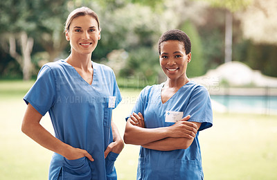Buy stock photo Portrait of two confident young nurses standing outside in the garden of a retirement home