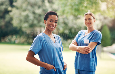 Buy stock photo Portrait of two confident young nurses standing outside in the garden of a retirement home