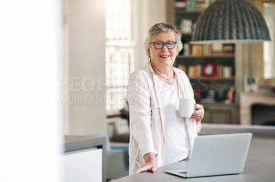 Buy stock photo Shot of a senior woman having coffee while using a laptop at home