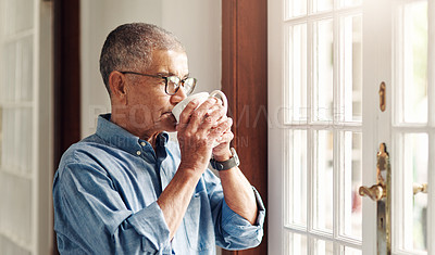Buy stock photo Shot of a senior man having coffee and looking thoughtfully out of a window