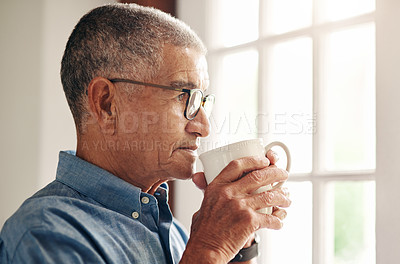 Buy stock photo Shot of a senior man having coffee and looking thoughtfully out of a window