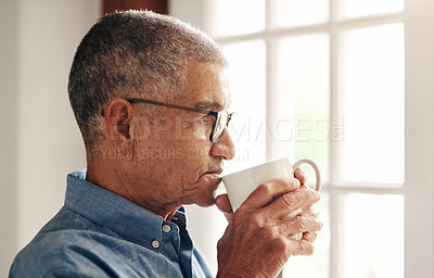 Buy stock photo Shot of a senior man having coffee and looking thoughtfully out of a window