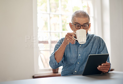 Buy stock photo Shot of a senior man having coffee and using a digital tablet at home