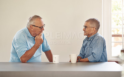 Buy stock photo Shot of two senior men having coffee and a chat at home