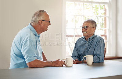 Buy stock photo Shot of two senior men having coffee and a chat at home