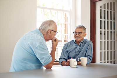 Buy stock photo Shot of two senior men having coffee and a chat at home
