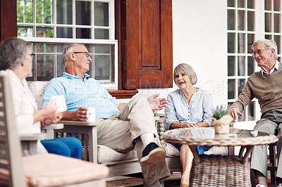 Buy stock photo Cropped shot of a group of senior citizens sitting together and enjoying a day out on the veranda