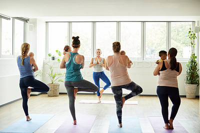 Buy stock photo Full length shot of a group of mothers holding their babies during a baby yoga class indoors