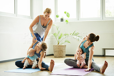 Buy stock photo Full length shot of two attractive young mothers sitting with their babies during a baby yoga class indoors