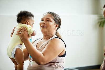 Buy stock photo Cropped shot of an attractive young mother posing with her baby during a baby yoga class indoors