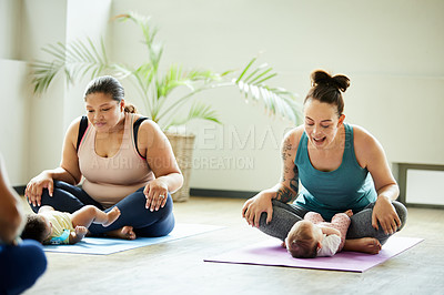 Buy stock photo Cropped shot of two attractive young mothers sitting with their babies during a baby yoga class indoors