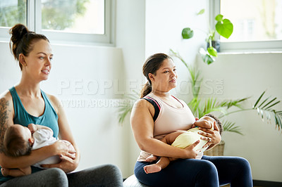 Buy stock photo Cropped shot of two attractive young mothers sitting with their babies during a baby yoga class indoors