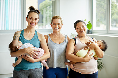 Buy stock photo Cropped portrait of two young mothers holding their babies and standing with their yoga instructor after a baby yoga class